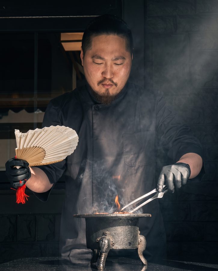 부채질하며 숯불을 다루는 셰프
